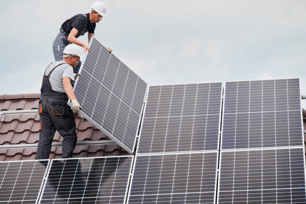 man worker mounting solar panels on roof of house. - painel solar imagens e fotografias de stock