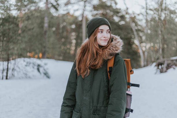 istock Woman enjoying nature in snowy forest 1367493875