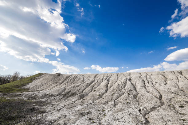 Beautiful view for a white chalk cliffs with rough splits on a blue sky background.
