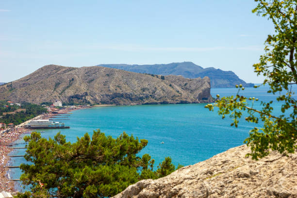 Panorama of the embankment of resort town of Sudak in the Crimea. Beautiful summer marine and mountain landscape. Travel photos. stock photo