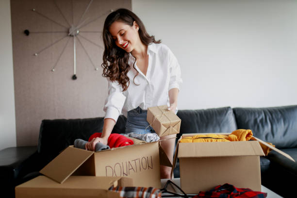istock Woman sorting clothing and packing donation box 1367497682