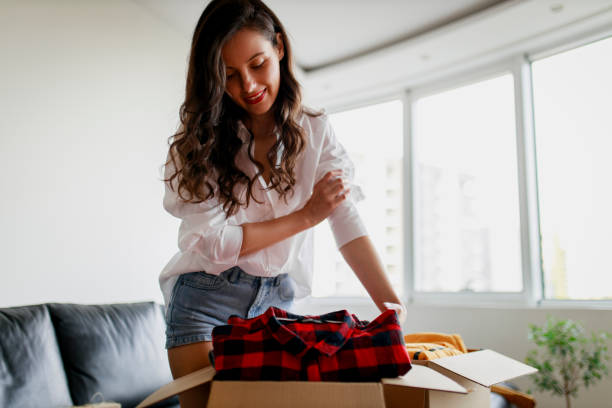 istock Woman sorting clothing and packing donation box 1367498859