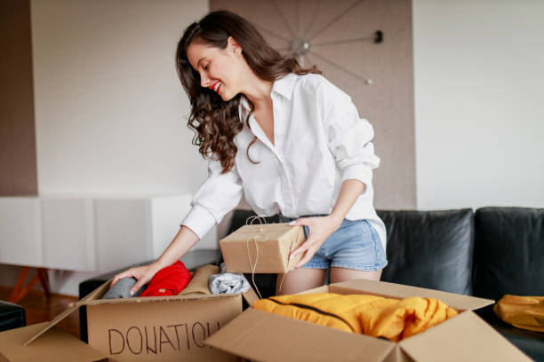 istock Woman sorting clothing and packing donation box 1367499916