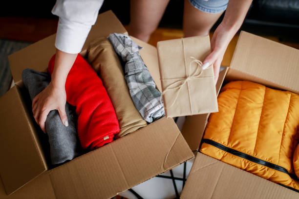 istock Woman sorting clothing and packing donation box 1367501330