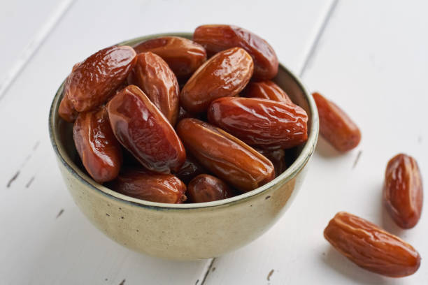 istock dates food in a bowl on white background 1367501610