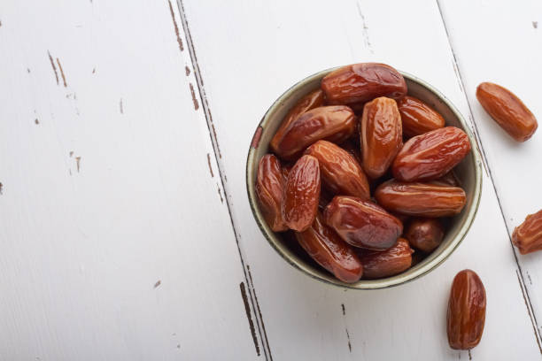 istock dates food in a bowl on white background copy space top view 1367501613