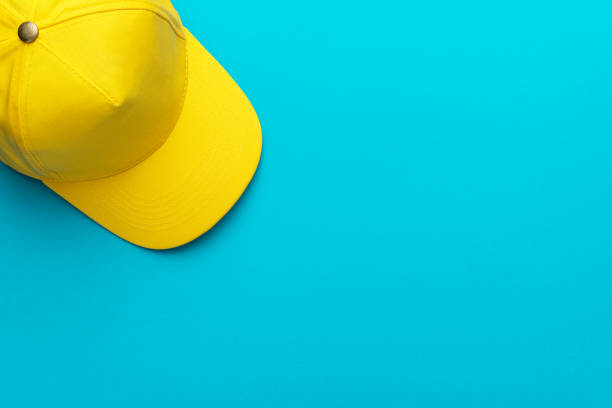 istock Top view of yellow baseball cap over turquoise blue background with copy space 1367501743