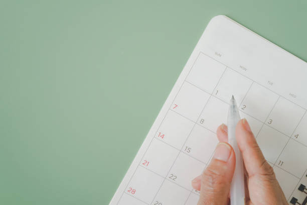 istock hand holding white pen to write on blank white planner, planning, schedule, timeline, routine concept 1367502356