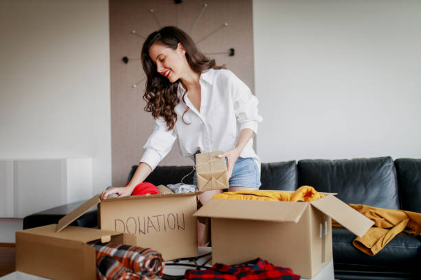 istock Woman sorting clothing and packing donation box 1367504505