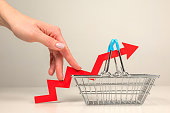 istock The fingers of a woman's hand step up the arrow of a chart lying on a shopping basket. Crisis and rising commodity prices concept 1367506137