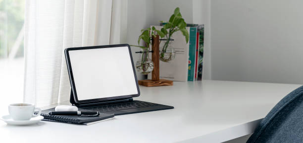 istock A simple workspace at home with portable tablet and keyboard on white table. 1367507050