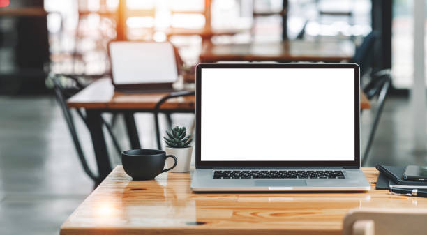 istock Creative workspace with white screen laptop computer on wooden desk in co-workspace. 1367508299