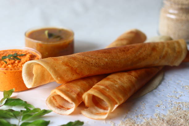 Crispy crepes made of little millets and lentils. Commonly known as little millet dosa. Plated as dosa rolls. Served with coconut spicy condiments and sambar Crispy crepes made of little millets and lentils. Commonly known as little millet dosa. Plated as dosa rolls. Served with coconut spicy condiments and sambar. Shot on white background thosai stock pictures, royalty-free photos & images