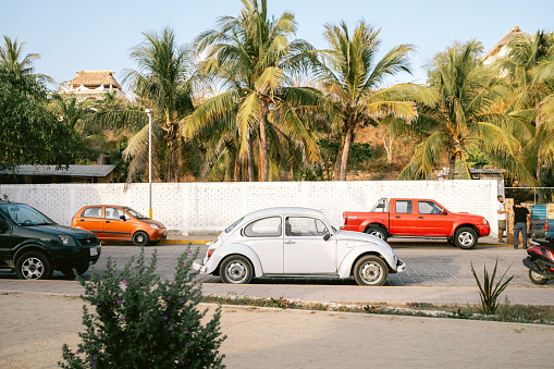 This street is opposite of Zicatela beach in Puerto Escondido Mexico. This scene features a classic Volkswagen Beetle, which you see a lot of in Mexico, and Central America overall