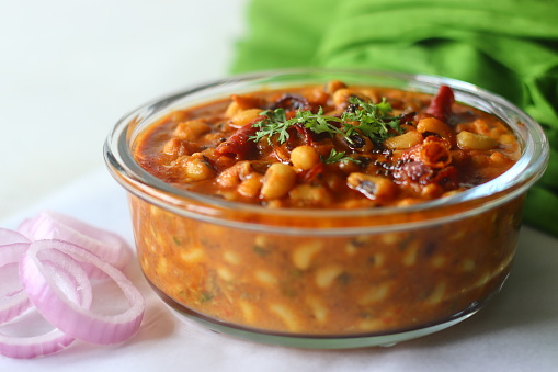 Black eyed beans or cowpea beans gravy. The gravy is cooked with onions, tomatoes and spices and by adding roasted coconut and onion garlic paste. Shot on white background
