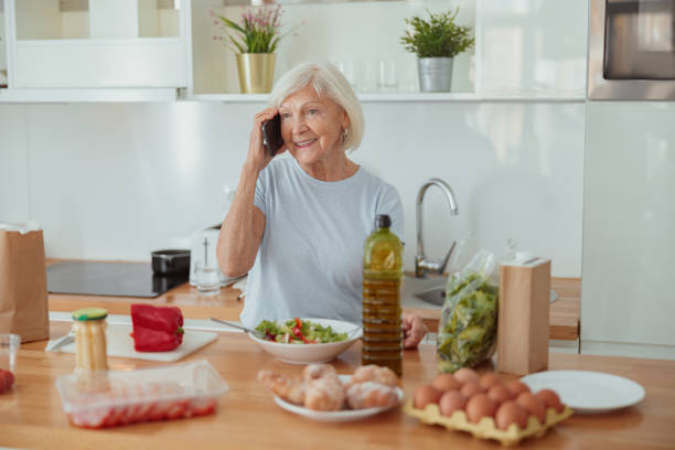 istock Happy aged female talking on mobile phone indoors 1367511552