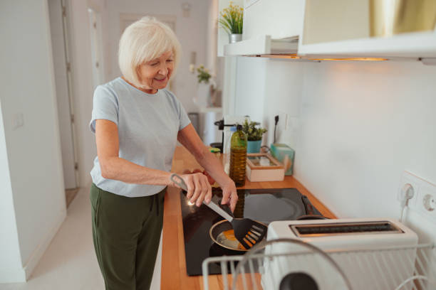 istock Senior woman is preparing meal in kitchen 1367511577
