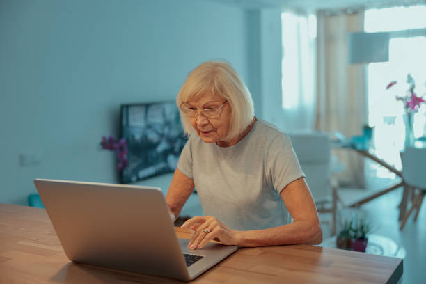 istock Senior woman communicating during video chat on laptop indoors 1367511594