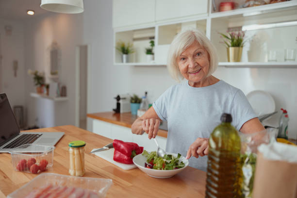 istock Senior female making salad at home kitchen 1367511619