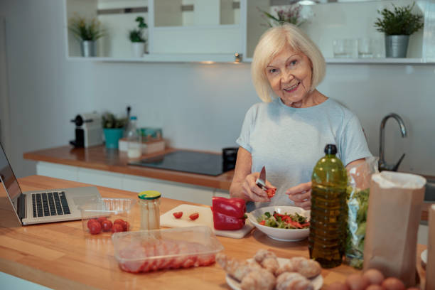 istock Aged woman chopping vegetables at home kitchen 1367511626