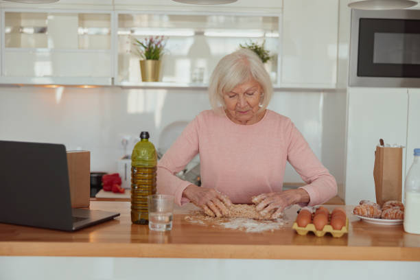 istock Senior woman is preparing meal in kitchen 1367511647