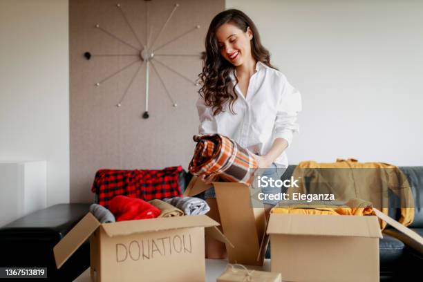 Woman Sorting Clothing And Packing Donation Box Stock Photo - Download Image Now - Decluttering, Closet, Charitable Donation