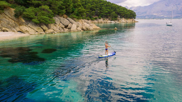istock Man paddleboarding on beautiful calm sea 1367515341