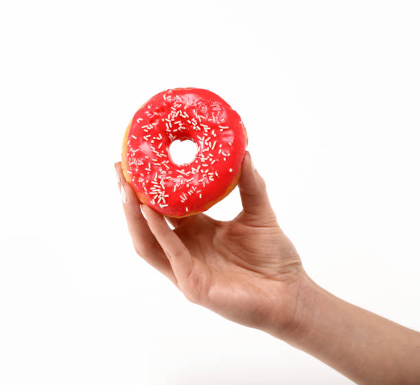 Woman hand holds red donut over white