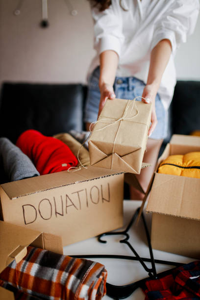 istock Woman sorting clothing and packing donation box 1367518188