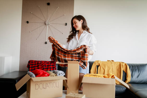 istock Woman sorting clothing and packing donation box 1367518316