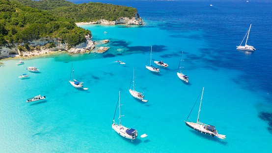 Group of sailboats anchored in bay with amazing beach. Crystal clear water has a beautiful color. Aerial view