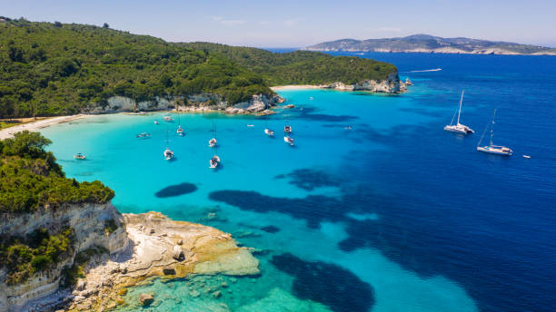 Group of sailboat near beautiful beach Group of sailboats anchored in bay with amazing beach. Crystal clear water has a beautiful color. Aerial view sailing dinghy stock pictures, royalty-free photos & images