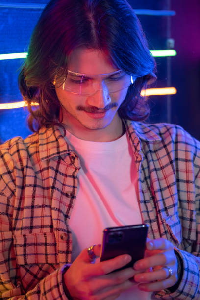 istock Night Man using smartphone in old phone box at night with neon light 1367521875