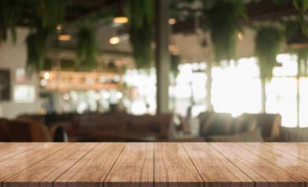 istock Empty wooden table top with lights bokeh on blur restaurant background. 1367524825