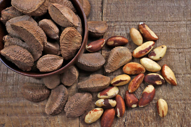 istock Wooden bowl with Brazil nuts on rustic wooden table 1367526513