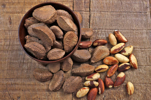istock Wooden bowl with Brazil nuts on rustic wooden table 1367526521