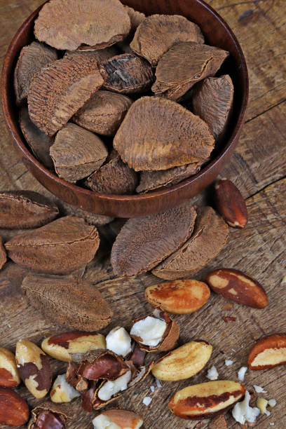 istock Wooden bowl with Brazil nuts on rustic wooden table 1367526574