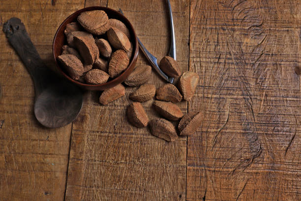 istock Bowl with Brazil nuts on wooden table. Space for text 1367527115