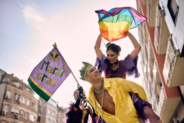 below view of couple in piggybacking on street carnival during mardi gras celebration. - gay pride flag gay pride gay man homosexual imagens e fotografias de stock