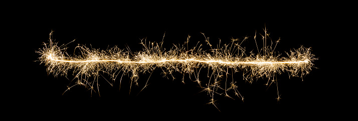 Bright line made of sparks against black background, celebration concept