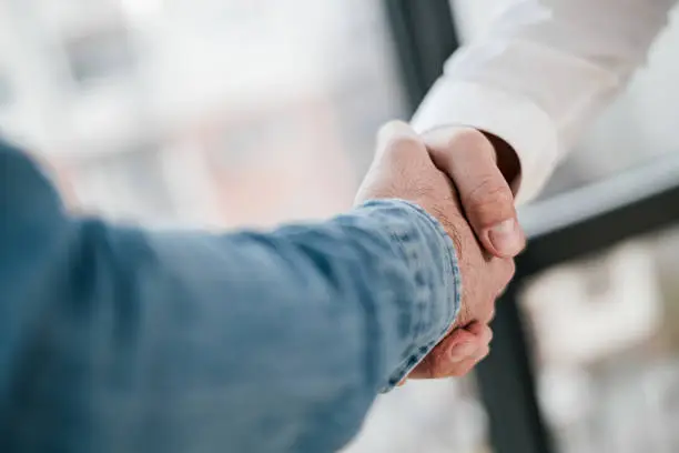 Photo of Close up shot of teamwork handshake in the office businessman entrepreneur freelancer shaking hands for successful negotiations and company business merger and acquisition