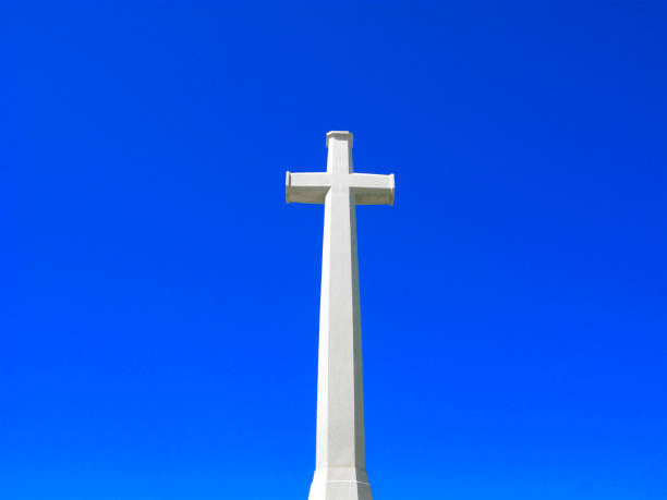 Photo of a large white double cross on a blue sky with white clouds