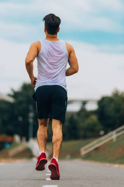 istock Athletic man jogging outside, training outdoors. Running on road at sunset 1367532626