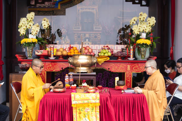 les moines s’assoient tête à tête à la table rouge tout en priant ensemble - zen like women temple meditating photos et images de collection