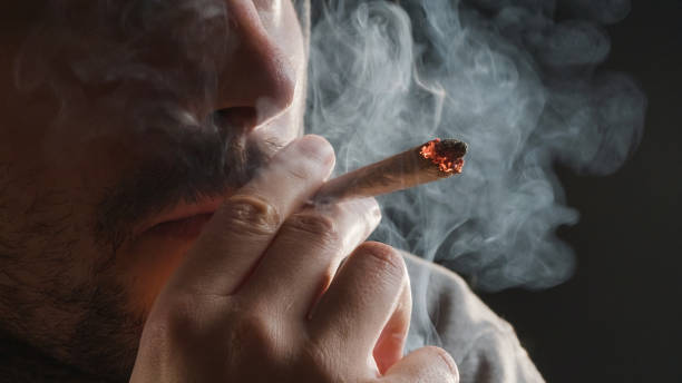 homme fumant un joint de marijuana - fumer du tabac photos et images de collection
