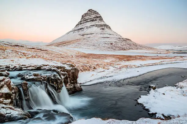 Kirkjufell mountain and waterfall at sunrise in Snaefellsnes peninsula in winter time, Iceland