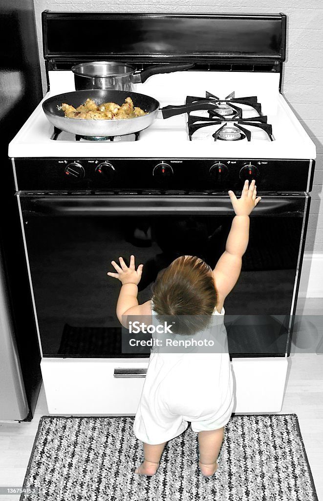 Bébé atteindre pour une cuisinière - Photo de Enfant libre de droits