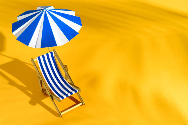 Concept of summer vacation. Top view of Miniatures beach chair with umbrella and shadow of palm leaves on orange background. Creative still life with copy space stock photo