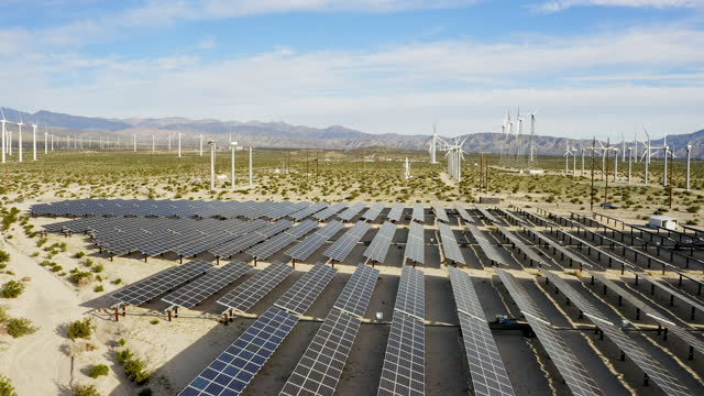 Aerial View over Solar Panels and Windmills