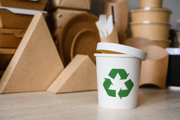 istock A white plastic container or glass with a green recycle symbol on the background of ecological utensils. The concept of using biodegradable materials for production. Selective focus. 1367542857